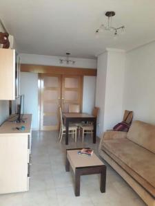 ein Wohnzimmer mit einem Sofa und einem Tisch in der Unterkunft Bajo con gran terraza en Ribera de Cabanes in Cabanes