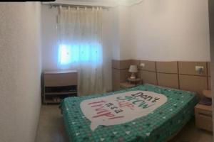 ein Schlafzimmer mit einem Bett mit einem glücklichen Neujahrszeichen darauf in der Unterkunft Bajo con gran terraza en Ribera de Cabanes in Cabanes