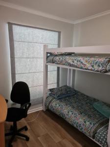 a bedroom with two bunk beds and a desk and a chair at Main Sail 4 Port St Francis in St Francis Bay