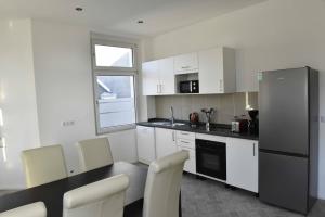 a kitchen with white cabinets and a table and chairs at Fewo Wuppertal in Wuppertal