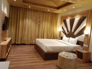 um quarto de hotel com uma cama grande e uma mesa em The Jungle Mountain Retreat em Mundaghat 