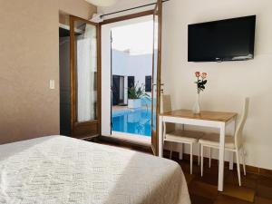 a bedroom with a bed and a table and a television at Le Patio Bleu in La Crau