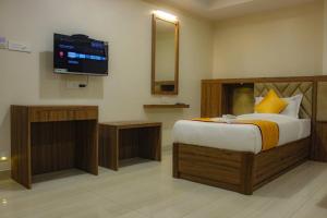 a bedroom with a bed and a flat screen tv at RR Mount Elite Suites in Chennai +16 photos