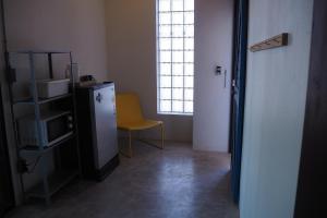 Ban Dan的住宿－No.210 Maikhao Bedroom Studio，客房设有冰箱、椅子和窗户。