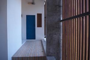 Ban Dan的住宿－No.210 Maikhao Bedroom Studio，走廊铺有木地板,设有蓝色的门