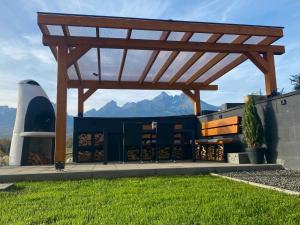 a wooden pergola on the side of a building at Chalet Sijkovsky in Stará Lesná