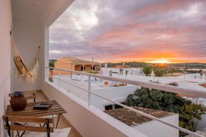 a balcony with a table and a sunset in the background at Moradia Villa Brava - Algarve in Alvor