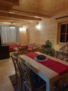 a living room with a table and a christmas tree at Anna's Mountain House in Kolašin