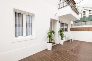 een balkon van een wit gebouw met twee potplanten bij Eva Boutique Apartment in Funchal