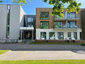 - un grand bâtiment avec des chaises devant dans l'établissement Sunny Aisa Apartment, à Pärnu