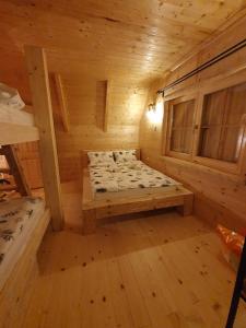 pokój z łóżkiem w drewnianym domku w obiekcie Anna's Mountain House w mieście Kolašin