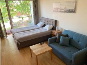 a bedroom with a bed and a blue couch at Sunny Aisa Apartment in Pärnu