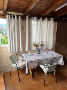 Mountain House في Gáïa: طاولة عليها كراسي و إناء من الزهور