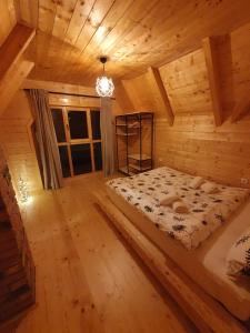 een slaapkamer met een bed in een blokhut bij Anna's Mountain House in Kolašin