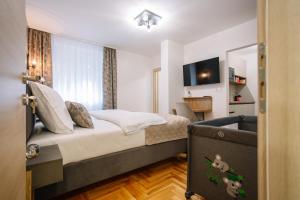 una habitación de hotel con una cama y un televisor en Apartments Hana City Center, en Livno