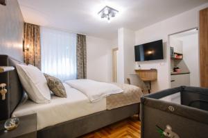 una habitación de hotel con una cama y un televisor en Apartments Hana City Center, en Livno