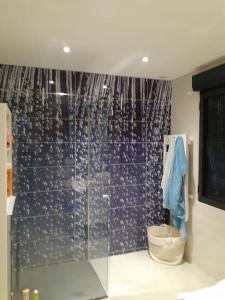 ein Bad mit einer Dusche und einer blau gefliesten Wand in der Unterkunft Villa des églantiers baie de somme in Cayeux-sur-Mer