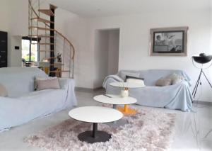een woonkamer met 2 tafels en een bank bij Villa des églantiers baie de somme in Cayeux-sur-Mer