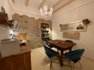 a kitchen with a wooden table and blue chairs at Guesthouse Riba in Vrsar