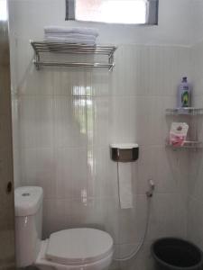 ein Bad mit einem weißen WC und einem Fenster in der Unterkunft Batajaya Cottage in Panjaitan