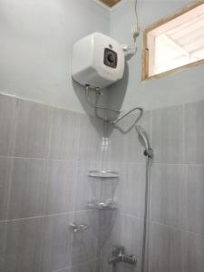 a shower with a camera on the wall of a bathroom at Batajaya Cottage in Panjaitan