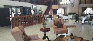 a lobby with chairs and tables in a restaurant at PHAKELA PRIVATE LODGE in Thabazimbi
