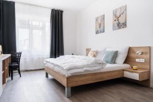 a bedroom with a bed and a desk and a window at Self check-in apartments by Amber in Bratislava