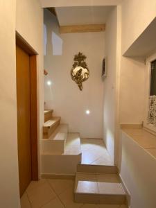 a hallway with stairs and a clock on the wall at Guesthouse Riba in Vrsar
