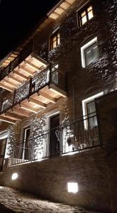um edifício de tijolos com varandas e luzes em Casagli Luxury Suites em Dimitsana