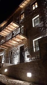 a brick building with balconies and lights on it at Casagli Luxury Suites in Dimitsana