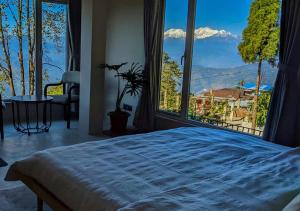 a bedroom with a bed and a large window at The Oak Retreat Lamahatta in Darjeeling