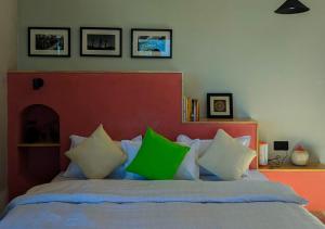 um quarto com uma cama com almofadas verdes e brancas em The Oak Retreat Lamahatta em Darjeeling