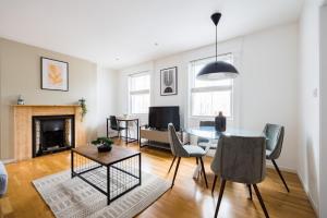 a living room with a table and chairs and a fireplace at The Bridge Flats in London