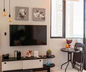 sala de estar con TV de pantalla plana y mesa en Flamingo Sea Point Sea View Luxury Best Position 1 Bedroom Apartment Queen Size Bed & Inverter For TV, en Ciudad del Cabo