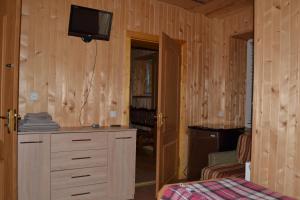 1 dormitorio con 1 cama y vestidor con TV en Fortuna, en Lazeshchyna