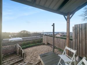 une terrasse couverte avec une chaise blanche et une clôture dans l'établissement The Lookout, à Torquay