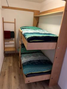 three bunk beds in a room with wooden floors at Au village de Nax, ravissant 2 pièces et demi avec terrasse in Nax