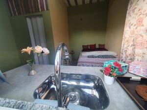 a bathroom with a sink and a bedroom with a bed at Espaço Alto da Colina em Penedo RJ in Itatiaia