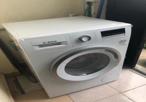 a white washing machine sitting in a room at Stoni Athi NHC in Nairobi