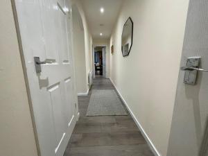 a hallway with a white door and a carpet at The Riverside in Alloa