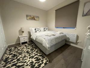a bedroom with a bed with a black and white rug at The Riverside in Alloa