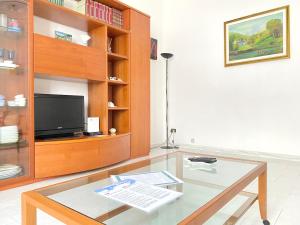 a living room with a tv and a glass table at Ca del Mare - FREE Parking in La Spezia