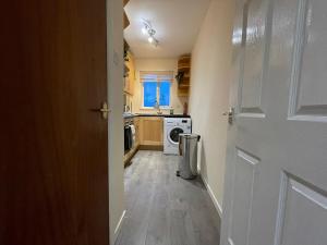 a kitchen with a washer and dryer next to a door at The Riverside in Alloa