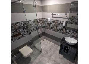 a bathroom with a toilet and a sink at The 9 Oaks by BOP group of Stay and Cafe in Mussoorie