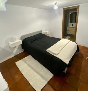 a bedroom with a black bed and a mirror at Casa Soportújar las flores in Soportújar