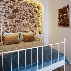 Ce lit se trouve dans un dortoir doté d'un mur en pierre. dans l'établissement Athena Luxury Studios, à Athènes