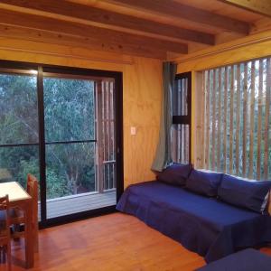 a living room with a bed and a large window at Posada IRSIS in La Pedrera