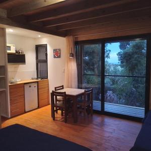 a kitchen with a table and chairs and a large window at Posada IRSIS in La Pedrera