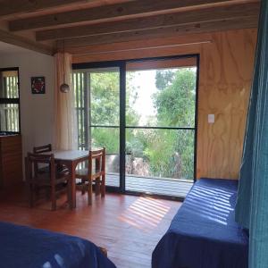 a bedroom with a table and a large window at Posada IRSIS in La Pedrera
