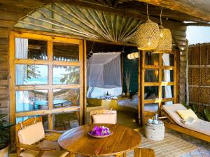 a room with a table and a room with a bed at Casa na Praia Tofo- beach front hotel in Praia do Tofo
